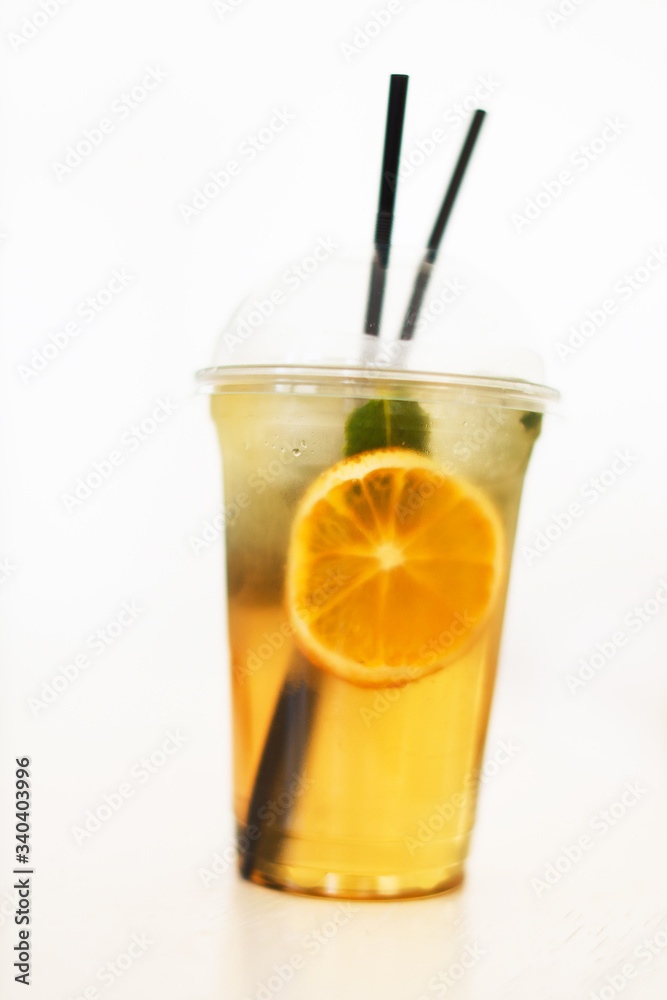 one fresh lemonade with orange slice in plastic cup on white background, ice tea, isolated, front view one fresh lemonade with orange slice in plastic cup on white background, ice tea, isolated, front view