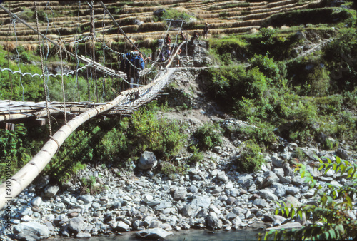 Hiker crossing suspension bridge photo