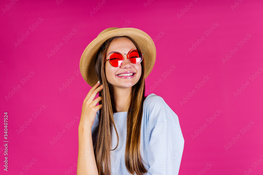 summer woman in a straw hat laughs, squinting, and straightens her hair background pink summer woman in a straw hat laughs, squinting, and straightens her hair background pink