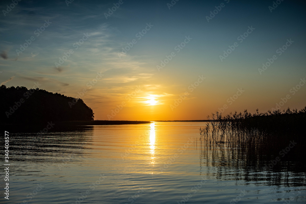 Zachód słońca nad jeziorem wśród szuwarów