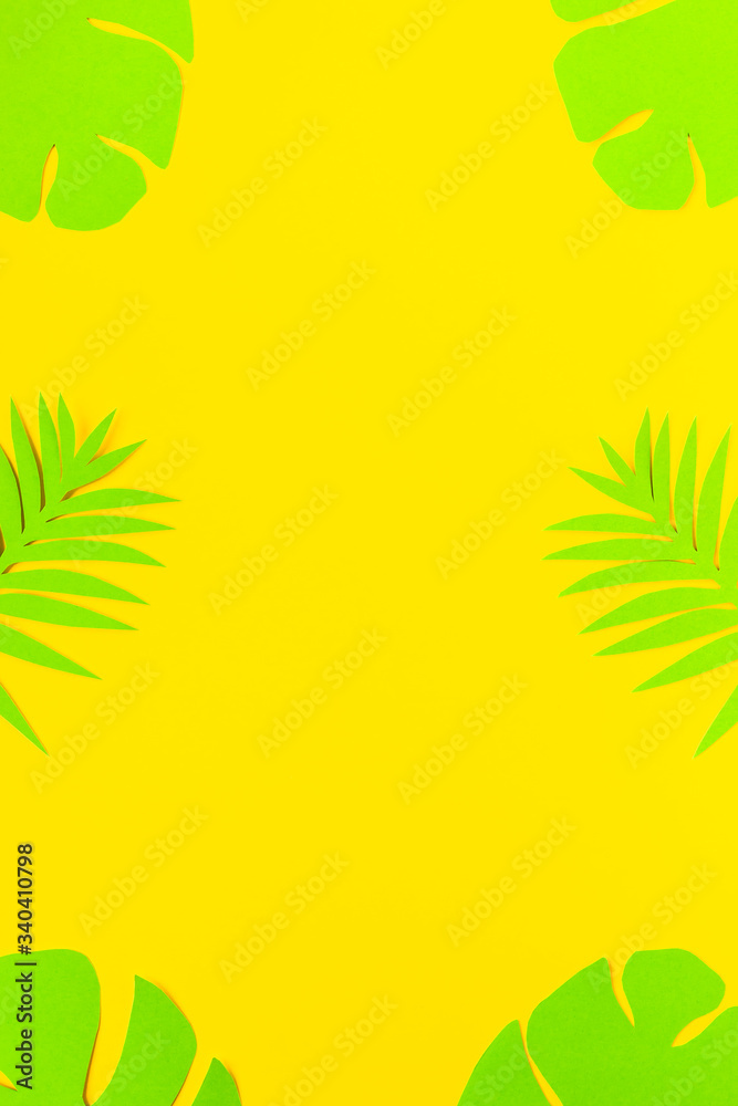 Summer backgroud. Green palm tree leaves on yellow backdrop. Paper art. Top view. Flat lay. Copyspace. Empty. Vertical layout