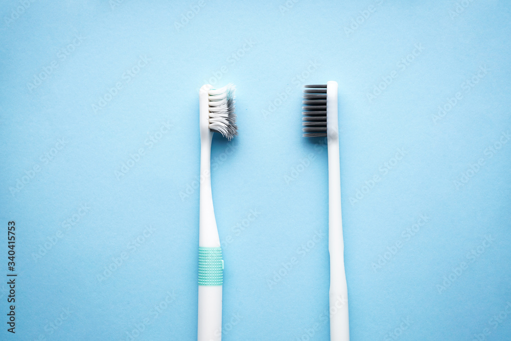 New and old toothbrushes on a blue background, close-up, flat lay. Dental and healthcare concept. New and old toothbrushes on a blue background, close-up, flat lay. Dental and healthcare concept.