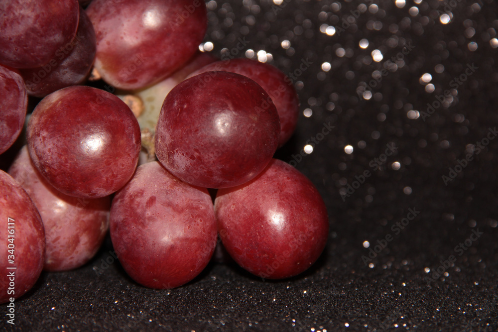 Large pink grapes on a black shiny background. Large pink grapes on a black shiny background.
