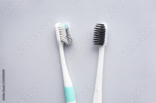 New and old toothbrushes on a gray background  close-up  flat lay.