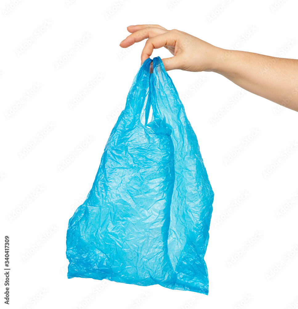 hand holds an empty blue plastic bag on a white background, concept of rejection of plastic