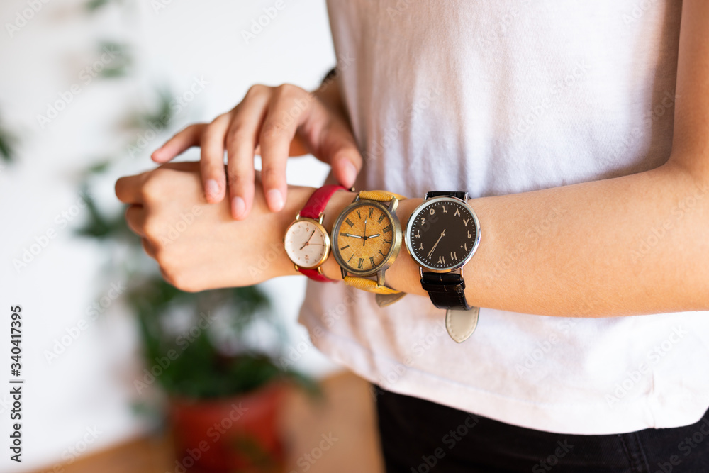 close up photo of female hands wearing three different hand watches with  different numerals. Black, yellow and read wrist watch. Stock Photo | Adobe  Stock