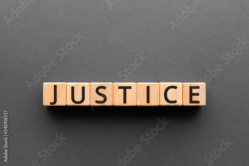 Justice - word from wooden blocks with letters, a judge or magistrate justice concept, black background