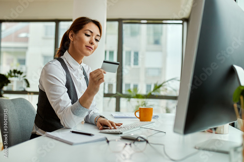 Young businesswoman shopping online while working in the office.