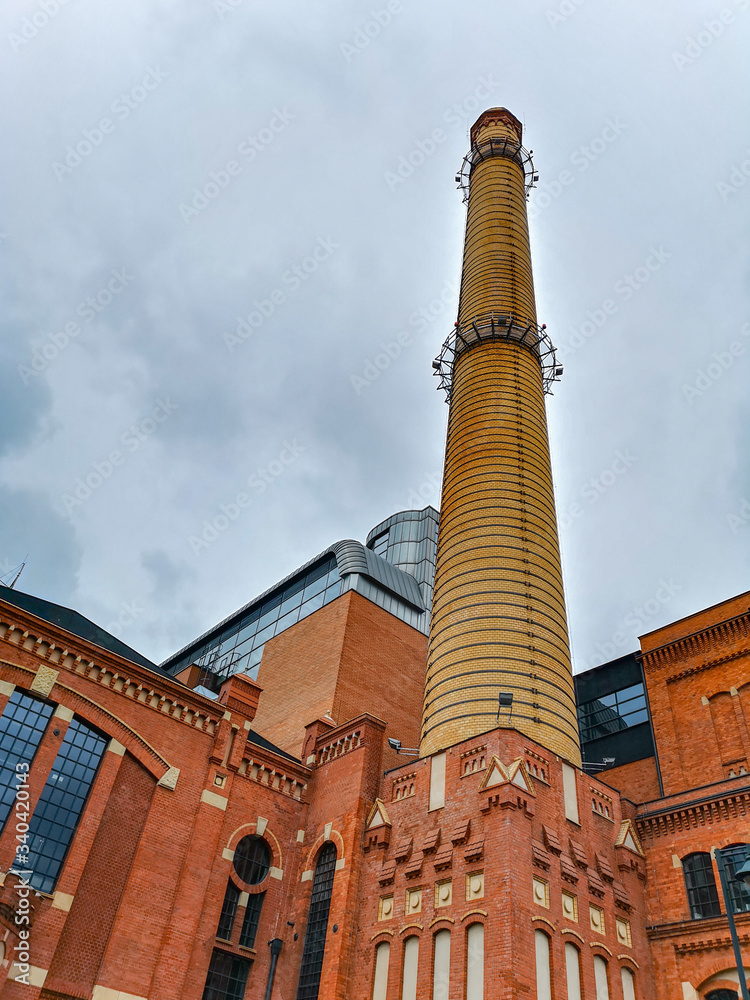 Chimney of renovated brick building in Łódź City at cloudy day