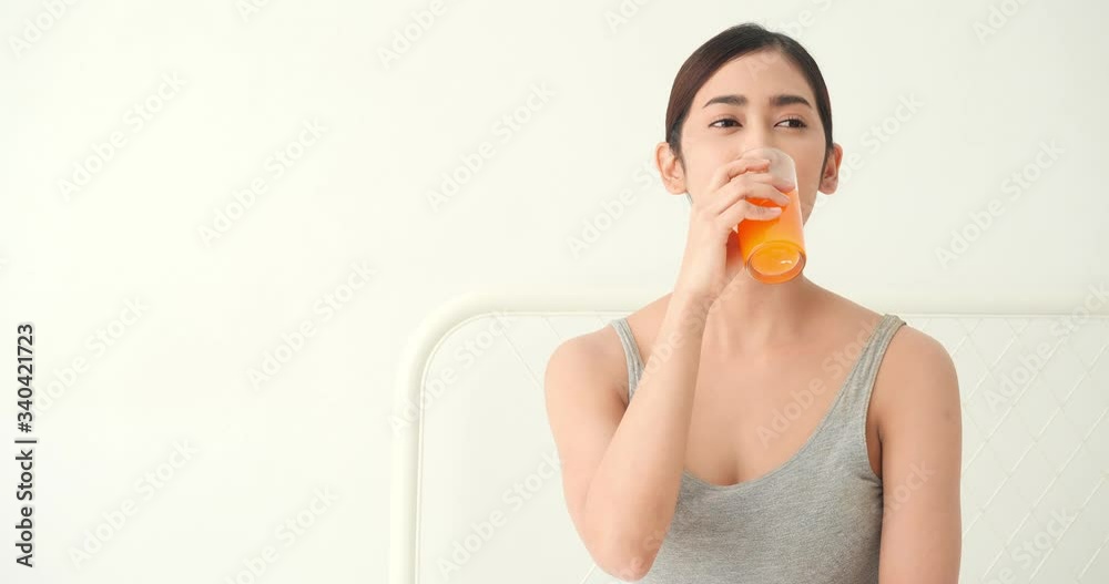 Beautiful asian girl drinking orange juice. Pretty girl holding glass fruit juice and detox drink. Concept of beverage, healthcare, food and drink. Beautiful asian girl drinking orange juice. Pretty girl holding glass fruit juice and detox drink. Concept of beverage, healthcare, food and drink.