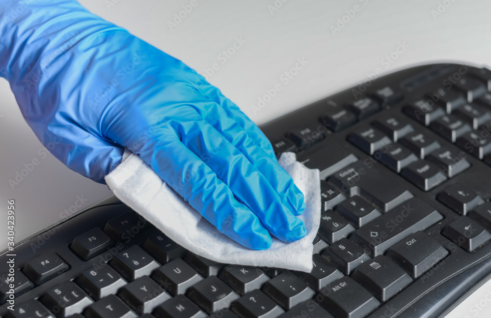 Woman with gloves cleaning and disinfecting computer keyboard with napkins  Corona virus cleaning and disinfection of your workspace from office and  home . Stop the spread of coronavirus . Stock Photo | Adobe Stock