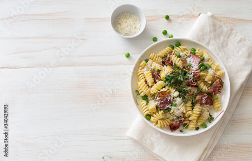 Italian pasta with fried bacon and green peas