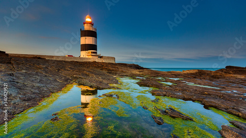 Lighthouse at Hook Head, County Wexford, Ireland Lighthouse at Hook Head, County Wexford, Ireland Lighthouse sea rock sunset landscape. Sunset l scene sunset  photo