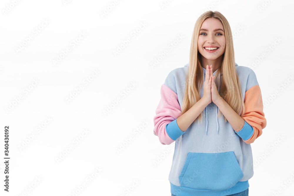 Enthusiastic, cute blond girl in hoodie, press palms together in pray, smiling grateful, thanking for help, asking for help or favour, saying namaste, tell please, begging something, white background Enthusiastic, cute blond girl in hoodie, press palms together in pray, smiling grateful, thanking for help, asking for help or favour, saying namaste, tell please, begging something, white background
