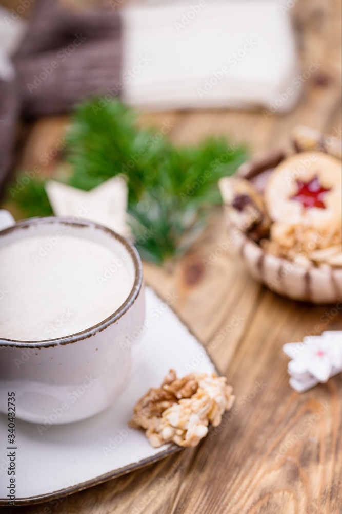 Christmas mood. White cup of coffee cappuccino and homemade cookies. Blurred background Christmas mood. White cup of coffee cappuccino and homemade cookies. Blurred background