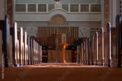 Φωτογραφία medium wide shot of an empty church sanctuary with afternoon sunlight pouring in