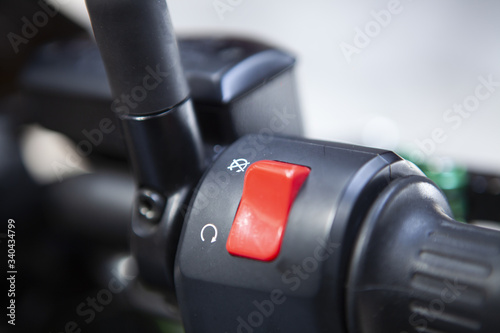 Macro detail of red stop engine button and gas handle of the motorcycle