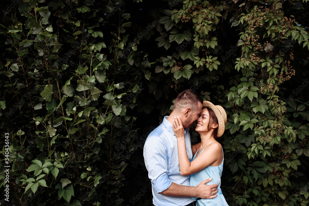 Hugging couple in love in summer clothes on the nature. Girl in a summer hat Hugging couple in love in summer clothes on the nature. Girl in a summer hat