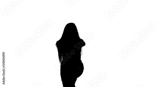 Medium long shot of a young beautiful girl with long hair dancing belly dance, oriental dance, exotic dance, black silhouette on a white background