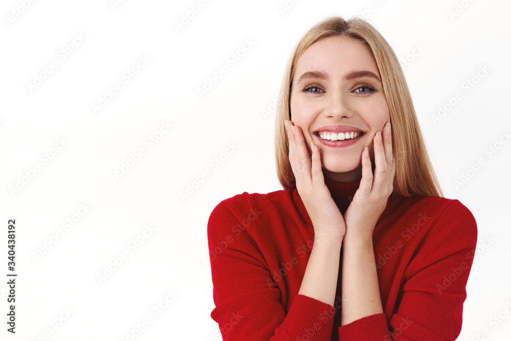 Beauty, women and fashion concept. Close-up portrait of attractive, feminine blond caucasian woman in stylish turtleneck, touching clean soft skin, hold hands on cheeks and smile happy Beauty, women and fashion concept. Close-up portrait of attractive, feminine blond caucasian woman in stylish turtleneck, touching clean soft skin, hold hands on cheeks and smile happy