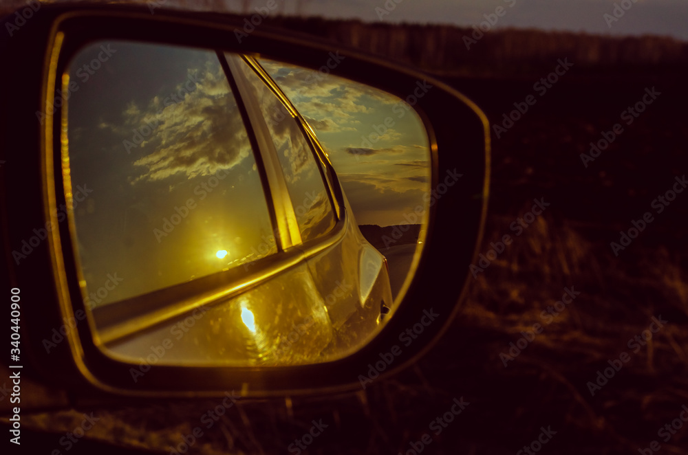 Reflection of the road in the mirror of a car closeup.