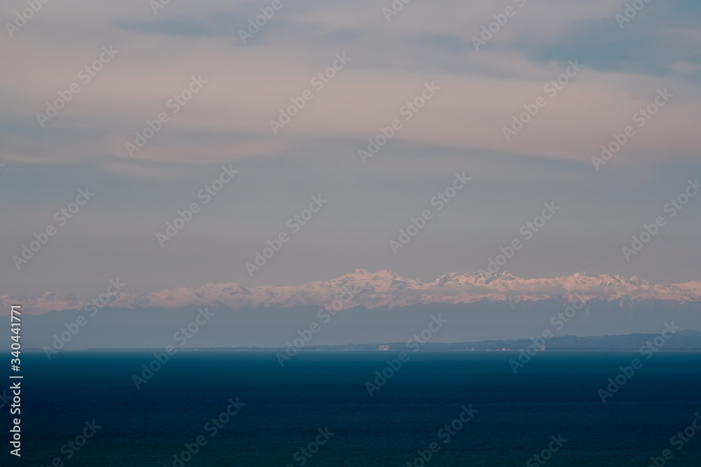 View of the foothills of the Caucasus. District of the city of Batumi. At the high peaks lies snow. On the lower mountains are residential buildings. The terrain has a different color.