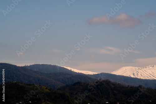 View of the foothills of the Caucasus. District of the city of Batumi. At the high peaks lies snow. On the lower mountains are residential buildings. The terrain has a different color. © Viktor