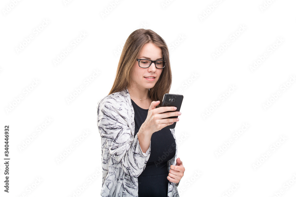 Portrait business woman in eyeglasses holding smartphone over white background. Using phone. Young businesswoman looking at mobile phone. business and technology concept Portrait business woman in eyeglasses holding smartphone over white background. Using phone. Young businesswoman looking at mobile phone. business and technology concept