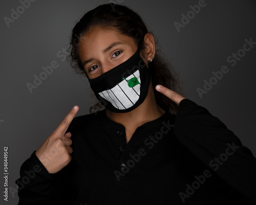 Girl pointing to smile in social distancing face mask