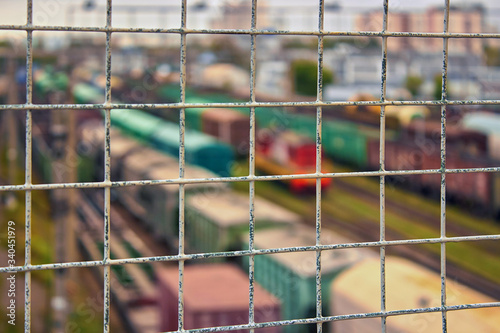 Freight trains and locomotives on the railway, view through the enclosing grate.