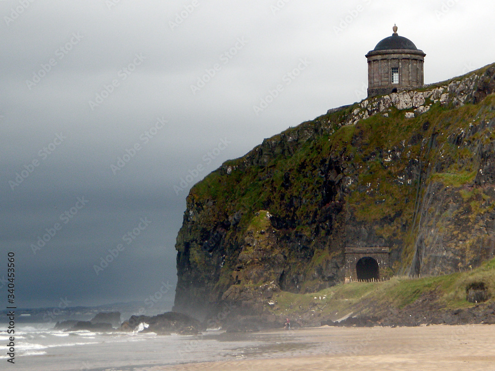 Round chapel standing on a rocky bluff overlooking the sea in Northern Ireland