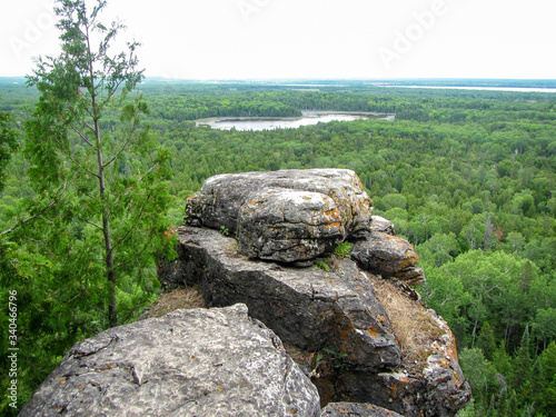 A pile of rocks forming a cliff overlooking a forest and lakes on Manitoulin Island  Ontario  Canada.