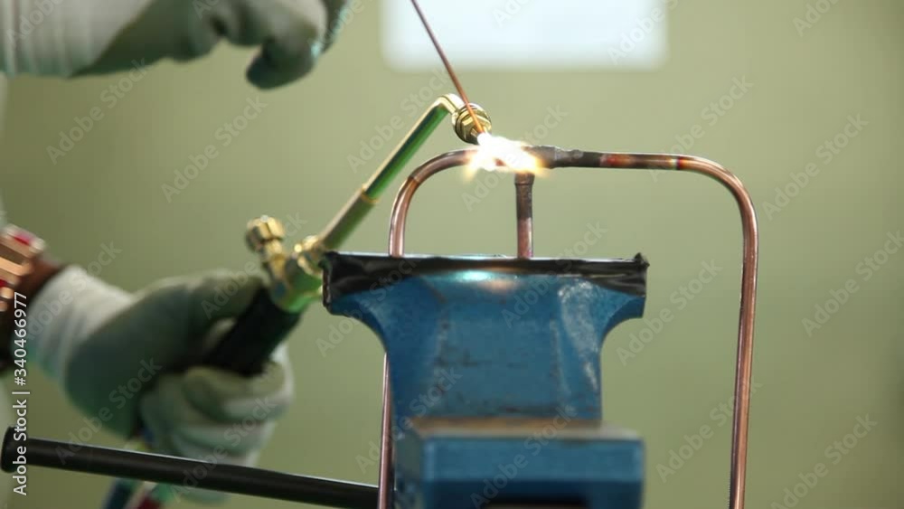 Sweating Pipe Fire Plumber sweating a copper pipe with a propane torch to weld solder ...