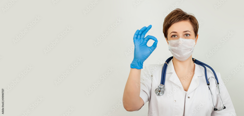 A health worker wearing a protective mask and showing ok sign. Young woman nurse or physician wearing a medical face mask, A health worker wearing a protective mask and showing ok sign. Young woman nurse or physician wearing a medical face mask,