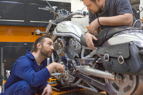 Photo of a two men in a motorcycle workshop.