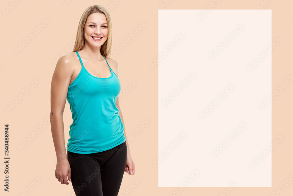 Pretty healthy smiling female athlete on peach shade yellow background with copyspace