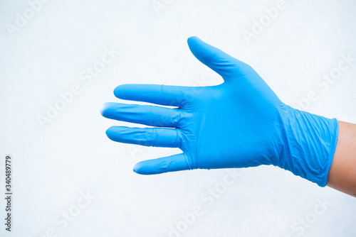 Hand put blue glove on white background. photo