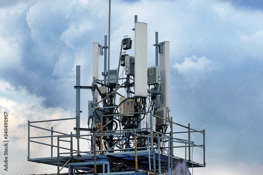 Telecommunication antennas for wireless cellular mobile and radio network installed at a transmission base station tower on a rooftop of a building.