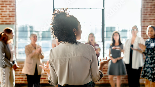 Young businesswoman talking to a crowd photo