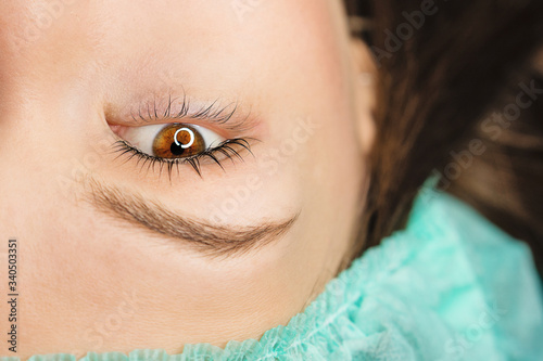 Woman after cosmetological procedure. Female eye with long eyelashes. Eyelash extensions, lamination, biowave, concept. photo