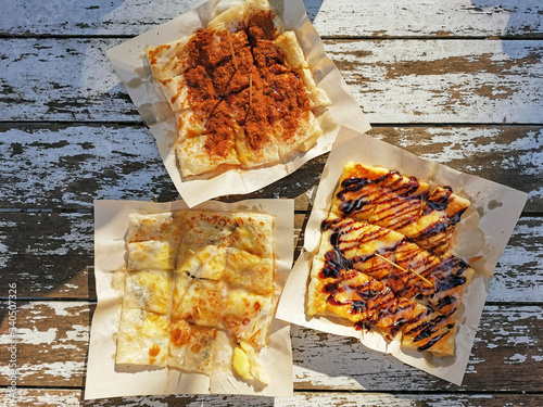 fried Roti with banana cooking on the street in Bangkok, halal Thailand on wooden background