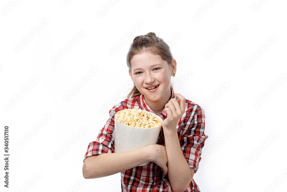 Cheerful girl in glasses with a bucket of popcorn in his hands eats it with an appetite on a white background Cheerful girl in glasses with a bucket of popcorn in his hands eats it with an appetite on a white background