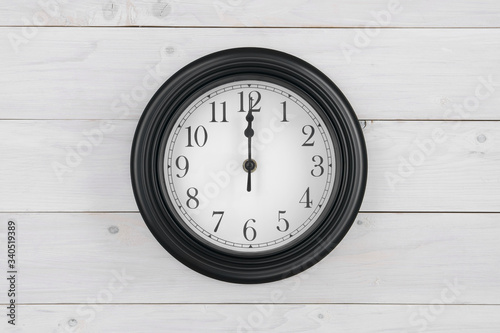 wall round clock black white with number and clockwise on twelve o'clock or 12 pm am and noon or midnight for time out or break working and school or lunch on wood wall or top view table and center