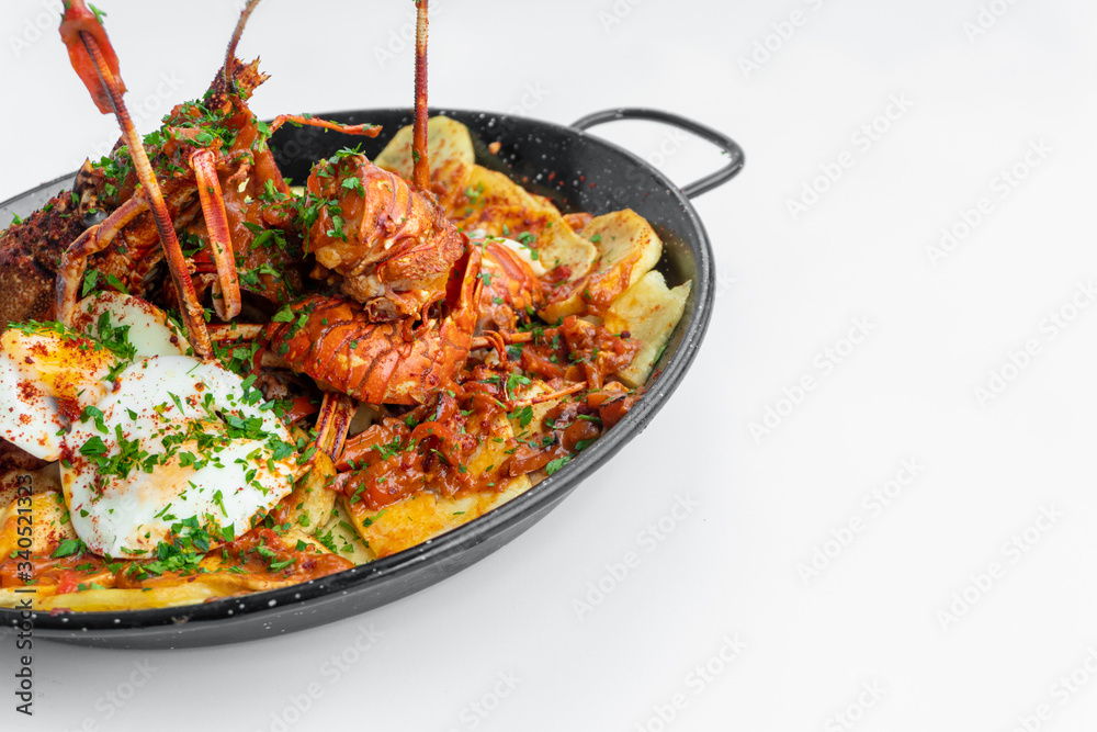Formentera Lobster with fried potatoes, eggs and parsley in a traditional paella pan. Caldereta de bogavante de Formentera Formentera Lobster with fried potatoes, eggs and parsley in a traditional paella pan. Caldereta de bogavante de Formentera