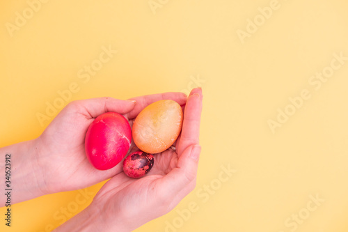 Easter eggs in palms on a yellow background