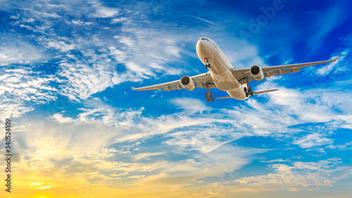 Commercial airplane flying in beautiful sky at sunset,travel concept.