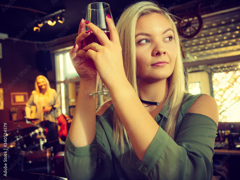 Girl with alcohol glass in pub club