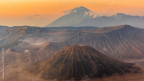 Sunrise over the Mount Bromo and Semeru volcano complex on a red, dusty morning giving the landscape a red, martian appearance