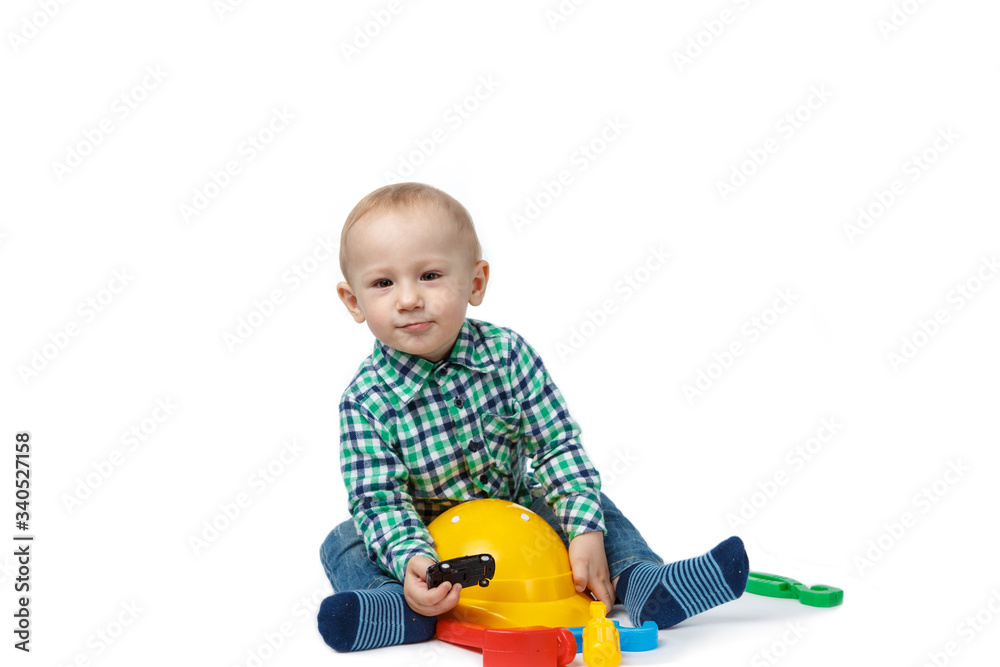 Cute baby plays with tools on a white background Cute baby plays with tools on a white background