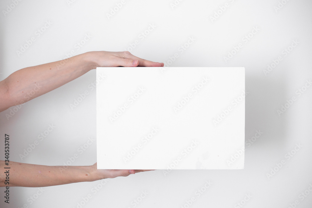 A parcel cardboard box in a delivery man hands on a white background. Delivery service concept. A parcel cardboard box in a delivery man hands on a white background. Delivery service concept.